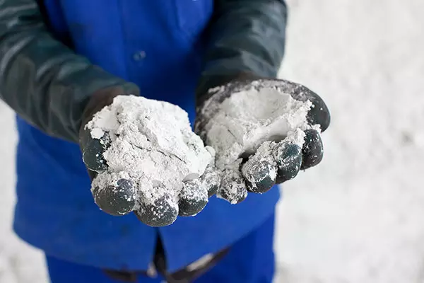 Hands wearing black gloves and showing paper pulp